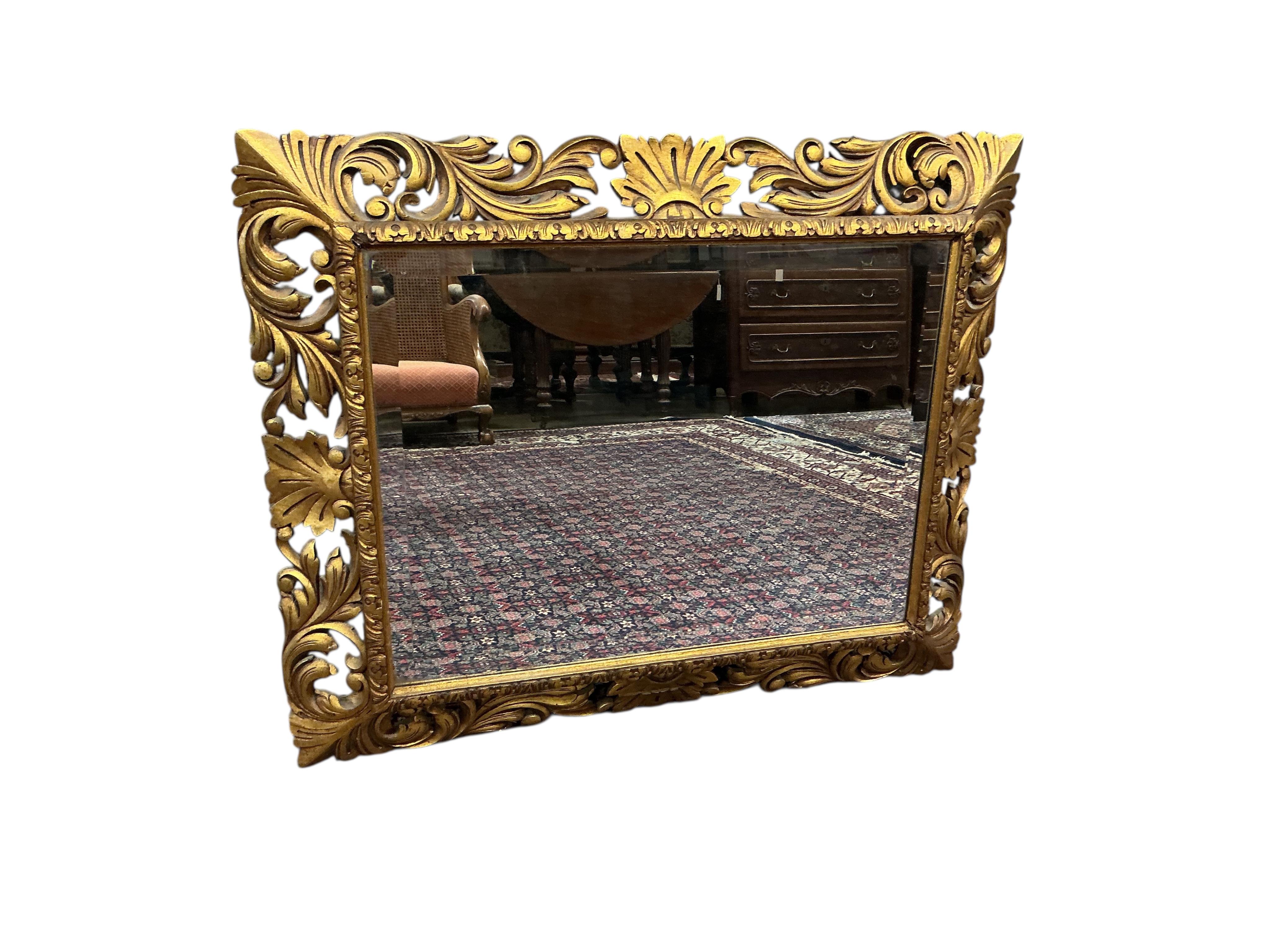 A rectangular carved giltwood Florentine style wall mirror with bevelled plate, width 110cm, height 90cm